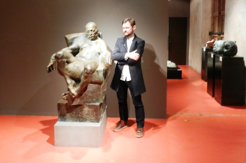 Grzegorz Gwiazda junto a la obra en bronce 'Sitting man' 